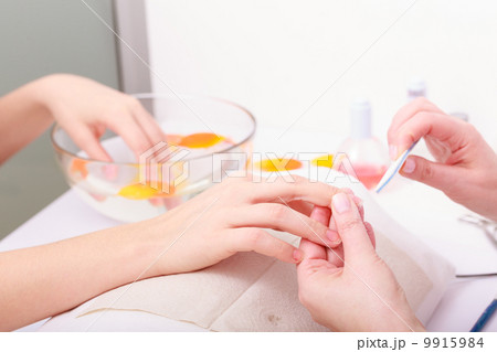 Beautician with file filing nails female client. Woman spa beauty salon Beautician with file filing nails female client. Woman spa beauty salon 9915984