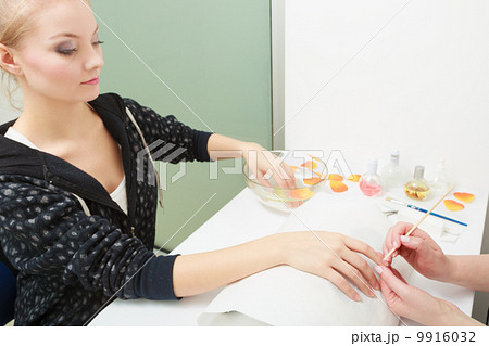 Beautician cleaning cuticles hands female client. Beauty salon. 9916032
