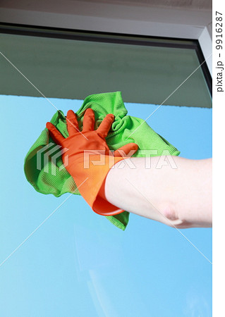 Gloved hand cleaning window with rag Gloved hand cleaning window with rag 9916287