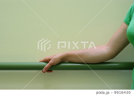 Woman hand and green banister 9916430