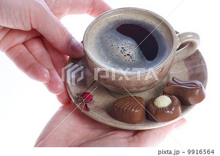 chocolate pralines, cup, black coffee and female hand on white 9916564