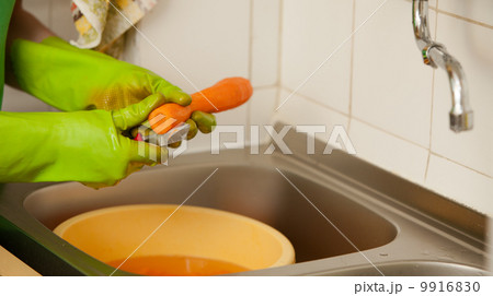 Woman hands slicing carrots in kitchen. Healthy nutrition Woman hands slicing carrots in kitchen. Healthy nutrition 9916830