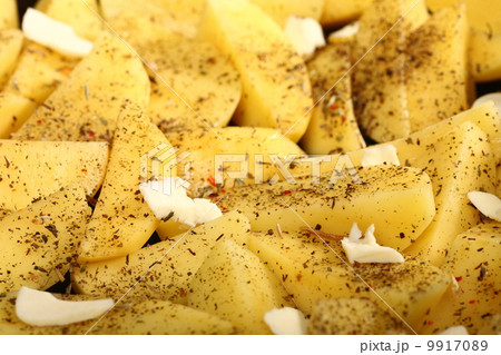 Raw potatoes with spices ready to be roasted Raw potatoes with spices ready to be roasted 9917089