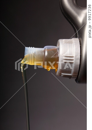 Can with car engine oil pouring black background 9917236