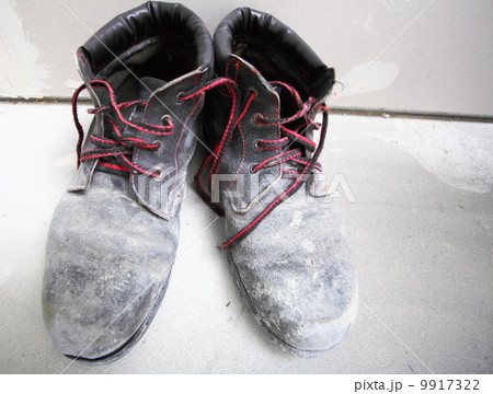 pair of old dirty work boots in building site 9917322