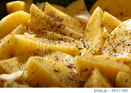 Raw potatoes with spices ready to be roasted Raw potatoes with spices ready to be roasted 9917700
