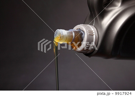 Can with car engine oil pouring black background Can with car engine oil pouring black background 9917924