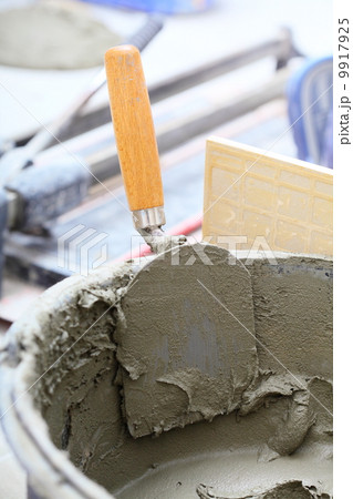 dirty trowel and bucket on building site dirty trowel and bucket on building site 9917925