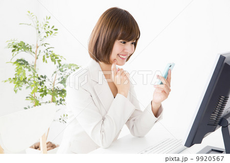 画面を見ながら電話をする女性 画面を見ながら電話をする女性 9920567