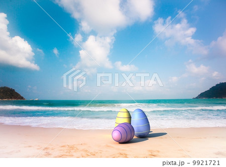 Three color Easter eggs on the sandy beach 9921721
