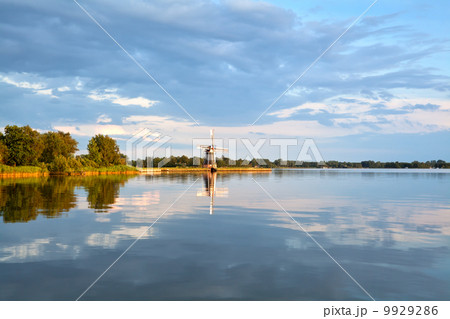 charming windmill by lake before sunset charming windmill by lake before sunset 9929286