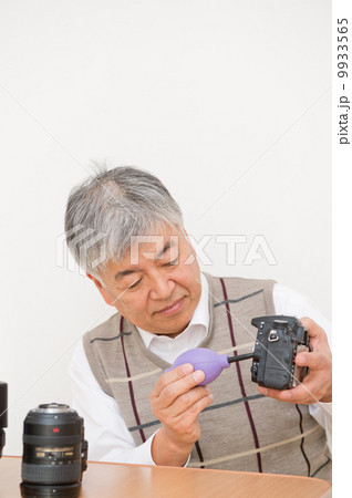 カメラの手入れをするシニア男性 9933565