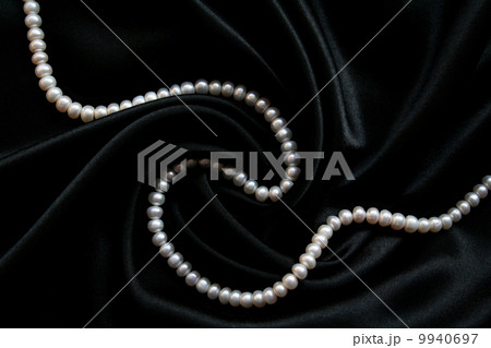 White pearls on the black silk 9940697