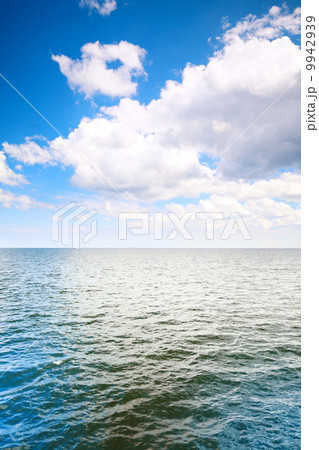Cloudy blue sky above a surface of the sea Cloudy blue sky above a surface of the sea 9942939