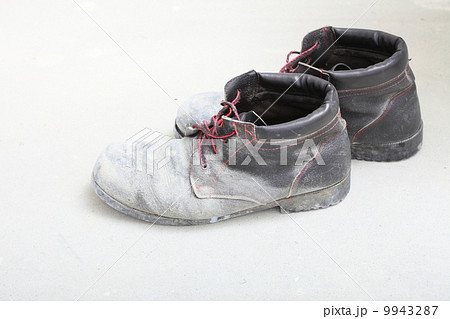 pair of old dirty work boots in building site pair of old dirty work boots in building site 9943287