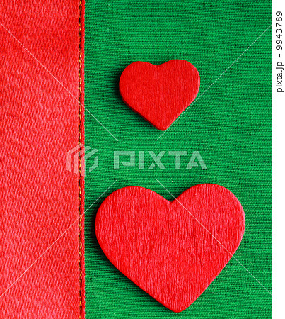 Red wooden decorative hearts on green cloth background Red wooden decorative hearts on green cloth background 9943789