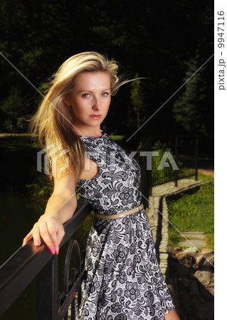 Fashion young woman in summer dress in park 9947116