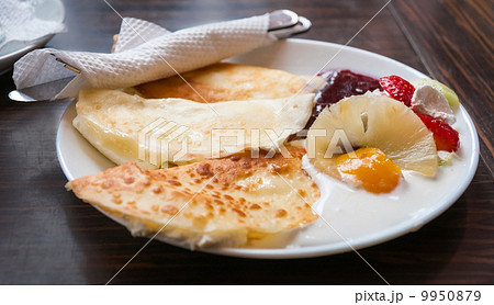 Pancakes on white plate and dark background with cream, strawber 9950879