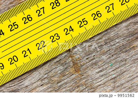 Yellow ruler on a wooden background 9951562