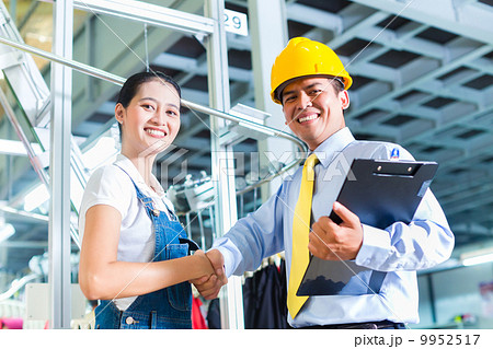 Asian foreman in textile factory giving training 9952517