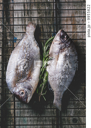 Tow raw dorado fish with rosemary on grill 9955622