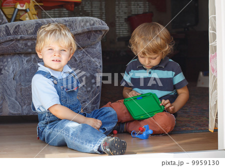 Two adorable little brother boy playing together indoor Two adorable little brother boy playing together indoor 9959130