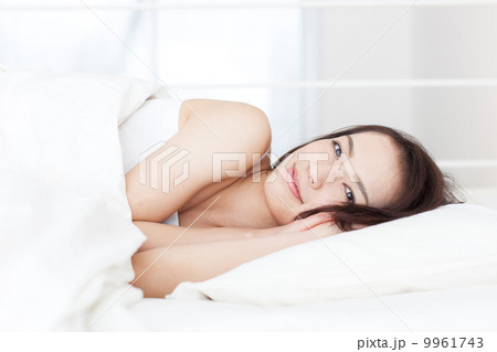 ベッドで寝る女性 9961743