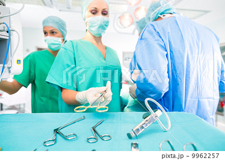 Surgeons operating patient in operating room Surgeons operating patient in operating room 9962257