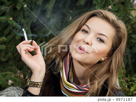 Young caucasian woman smokes a cigarette 9971187