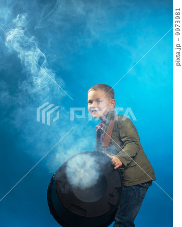Adorable boy posing in cloud of steam, close-up 9973981