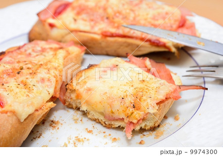 Remains of the ham and cheese baked toast on the plate. 9974300