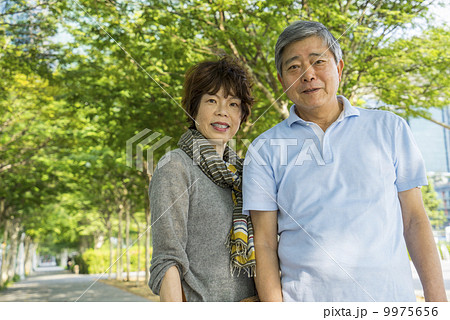 Portrait of an elderly couple traveller in a park with in an asian city on a sunny day 9975656