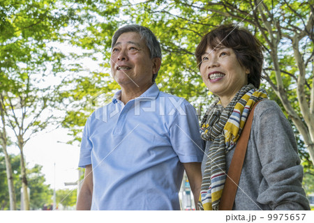 Portrait of an elderly couple traveller in a park with in an asian city on a sunny day Portrait of an elderly couple traveller in a park with in an asian city on a sunny day 9975657