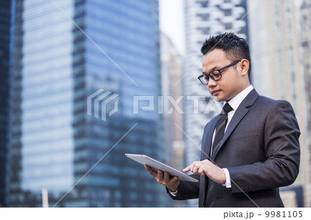 Young male malay executive using a tablet 9981105