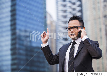 Young male malay executive on smart phone 9981110