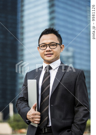 Young male malay executive with laptop 9981126