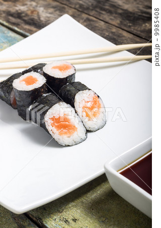Makisushi on white plate. Seafood traditional maki sushi rolls with chopsticks Makisushi on white plate. Seafood traditional maki sushi rolls with chopsticks 9985408