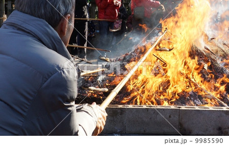 冬の風物詩・どんど焼きの餅を焼くシニア・横位置 冬の風物詩・どんど焼きの餅を焼くシニア・横位置 9985590