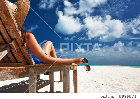 Woman at beach holding sunglasses Woman at beach holding sunglasses 9989971