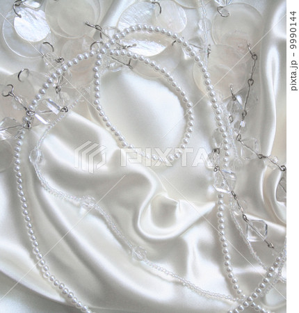 White pearls and nacreous beeds on white silk as wedding backgro 9990144