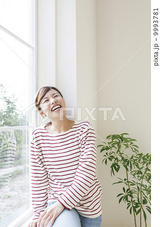 窓辺で笑う女性 9993781