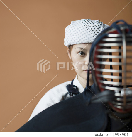 剣道着を着た女性と面頬 9993901