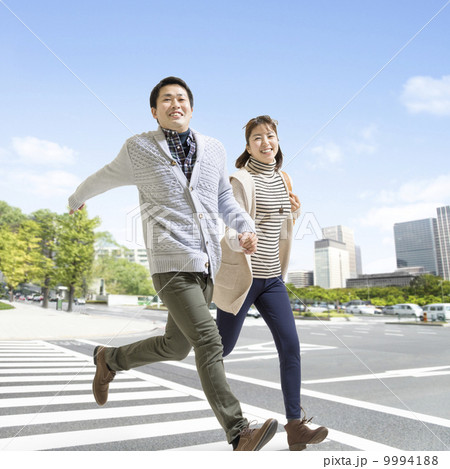 横断歩道を走る日本人カップル 9994188