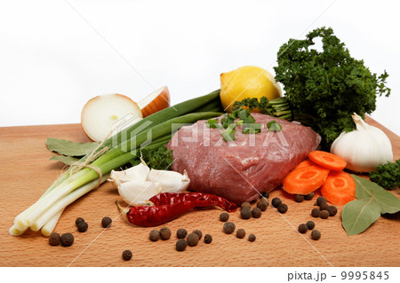 raw meat, vegetables and spices isolated on a wooden table. 9995845