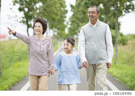 一本道で手をつなぐ祖父母と孫 10016490