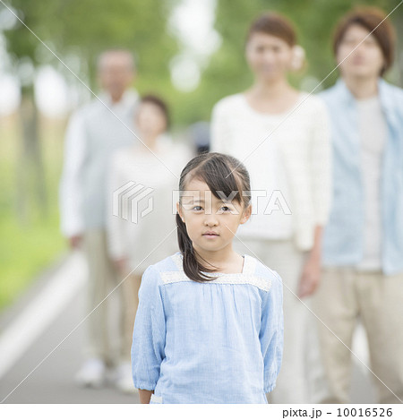 一本道に立つ女の子と見守る家族 10016526