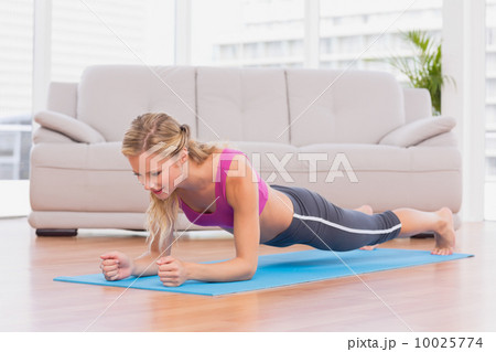Fit blonde in plank position on exercise mat Fit blonde in plank position on exercise mat 10025774