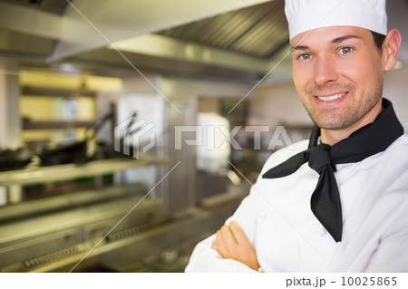 Closeup of a smiling male cook in kitchen Closeup of a smiling male cook in kitchen 10025865