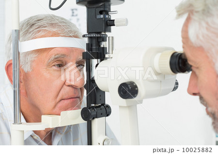 Optometrist doing sight testing for senior patient 10025882
