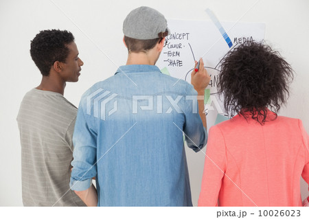 Artists using whiteboard in creative office Artists using whiteboard in creative office 10026023